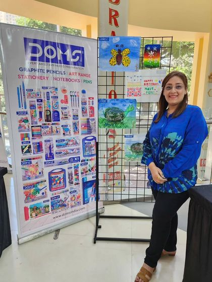 I am standing next to a display of some of the incredible artwork created by children during the workshop. Their talent is truly inspiring.