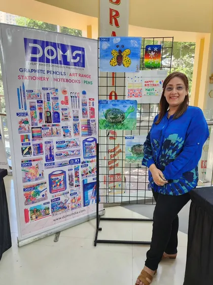 I am standing next to a display of some of the incredible artwork created by children during the workshop. Their talent is truly inspiring.
