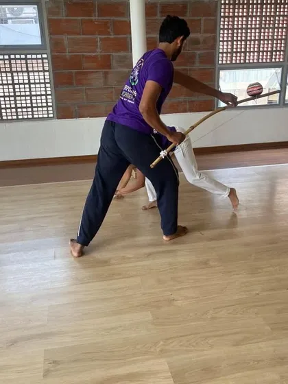An instructor demonstrates how to use the Berimbau and Caxixi together during a workshop. Learning the music is a journey in itself.