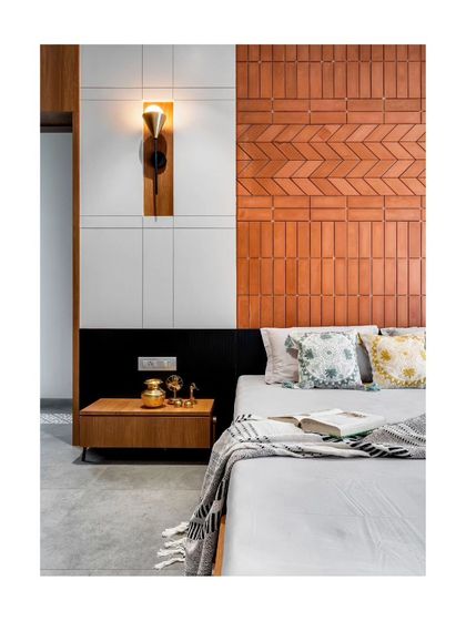 A close-up of the brick headboard, showing the herringbone pattern and the warm, tactile quality of the material.