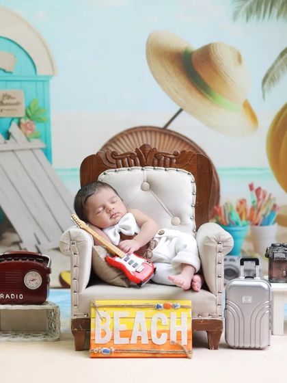 A close-up of the little beachgoer, complete with a tiny guitar and bowtie. These small details add personality and charm to our newborn adventure themes.
