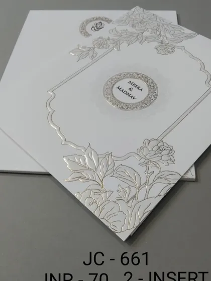 A clean white invitation with a silver foil floral design and a central monogram. The look is modern, elegant, and perfect for a sophisticated couple.