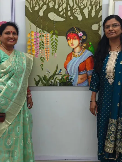 Two visitors admiring a beautiful painting by a fellow artist at our group exhibition. The gallery is filled with so much talent.