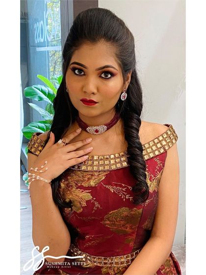 This Sangeet makeup look is all about glamour. The off-shoulder gown is complemented by a bold eye, a deep red lip, and a chic twisted hairstyle.