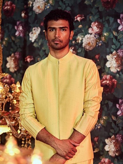 For a more subtle look, this pintucked bandhgala jacket in a vibrant yellow offers texture and sophistication.
