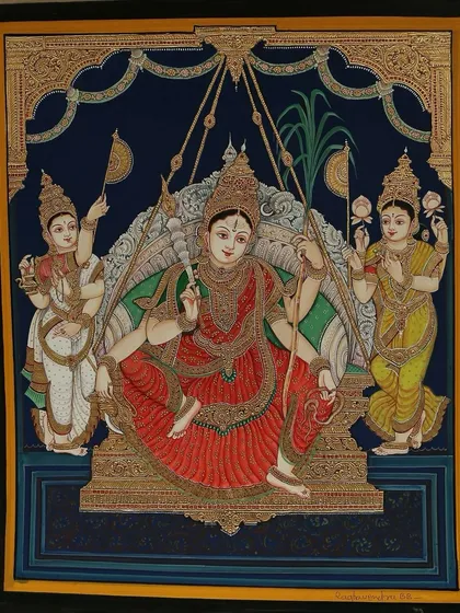 This stunning painting of Goddess Rajarajeshwari seated with Lakshmi Devi and Saraswathi Devi radiates elegance with its intricate work of pure gold leaves.