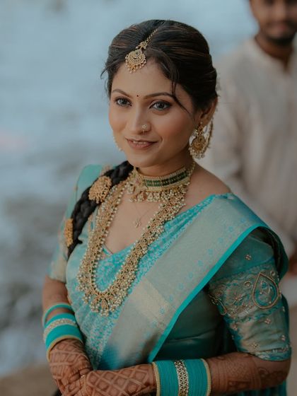 A close-up portrait of the bride. Her makeup is soft and elegant, with a focus on her expressive eyes.