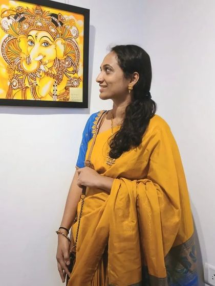 A visitor enjoying the bright, happy colors of a Kerala mural Ganesha painting.