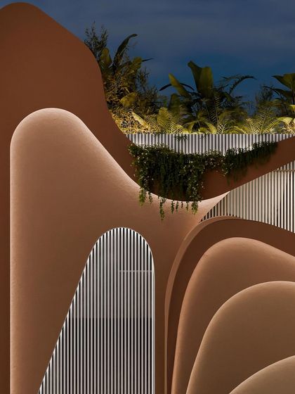 A dramatic nighttime shot of the facade's curves, highlighted by the integrated lighting.