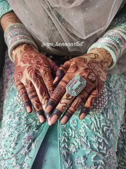 The beautiful stain on a bride's hands, adorned with traditional bangles. This is a classic and timeless look for any wedding.
