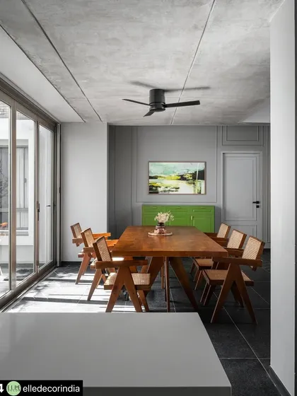 The dining area is flanked by large glass doors that open to an outdoor courtyard. This setup allows for natural light to flood the space and provides the option for an alfresco dining experience, seamlessly connecting meal times with nature.