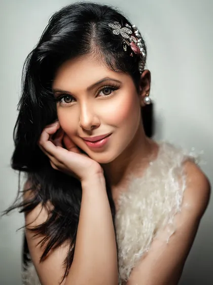 An angelic and soft portrait with a feather-textured top and a delicate hair accessory. This showcases a more ethereal and gentle side, suitable for beauty and accessory brands.