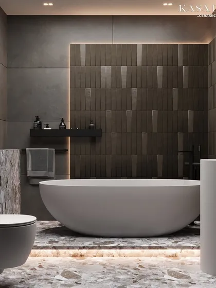 A complete view of a bathroom that blends multiple textures. The design features a smooth freestanding tub, a vertically textured accent wall, large-format concrete-look tiles, and a bold terrazzo floor, all working in harmony.