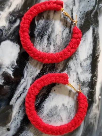These bold red macrame hoop earrings are crafted from a single, continuous thread. They are surprisingly lightweight and make a vibrant statement.