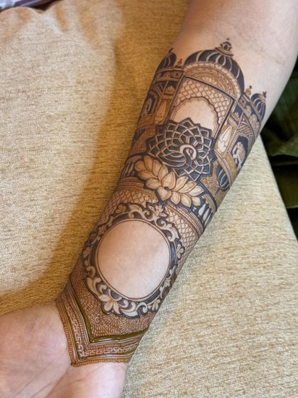 A close-up of the arm design, featuring a palace scene with a lotus and a blank frame for personalization, like adding a portrait or name.