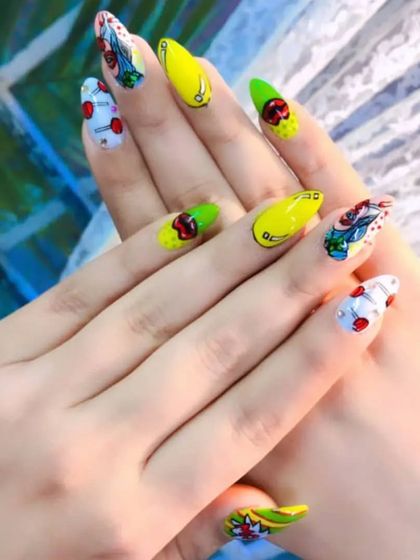 A vibrant and playful pop-art inspired design. This set features bright yellow and green nails with cartoonish, comic-book style art of cherries and roses.