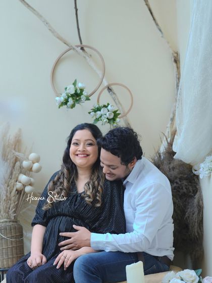 A smile that says it all. This beautiful studio portrait captures the shared happiness and contentment of a couple eagerly awaiting their little one.