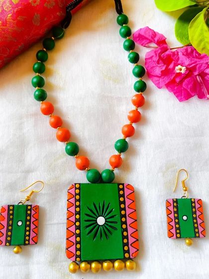 This square pendant set is in a lovely green and orange, reminiscent of the Indian flag.
