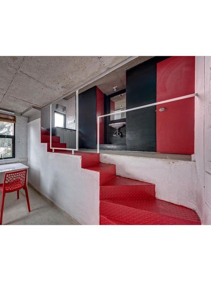 The folded red steel plate staircase is a central feature in each student housing unit. It provides access to the loft and bathroom while also serving as a vibrant, sculptural element that injects color and character into the space.