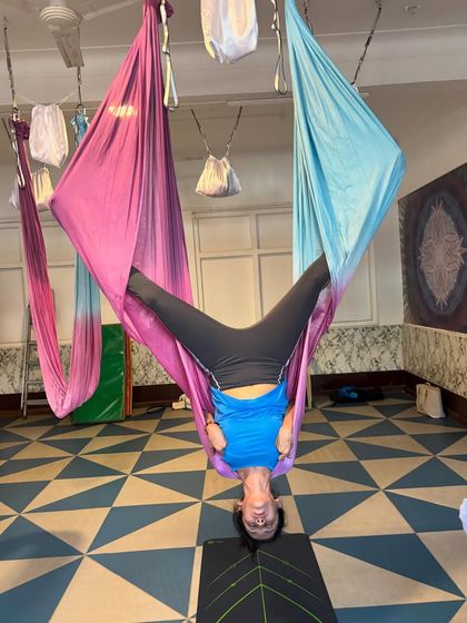 A happy moment captured mid-inversion. This wide-legged inverted pose not only stretches the inner thighs but also brings a healthy rush of blood flow to the brain, leaving you feeling refreshed.