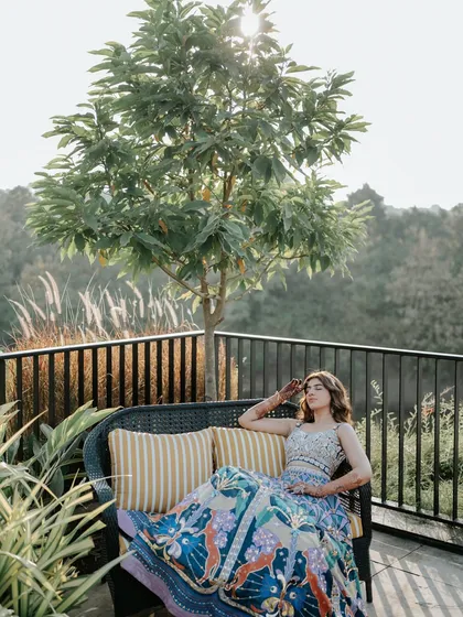 A bride enjoying a quiet moment during her Mehendi. The beautiful light and serene setting provide a peaceful contrast to the usual high energy of pre-wedding events.