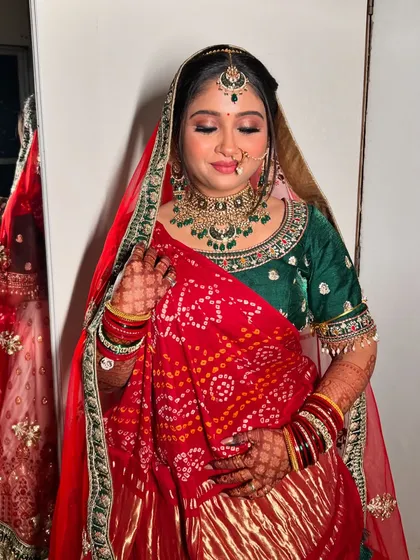 A lovely portrait of the bride, showcasing her complete look with the traditional Gharchola drape.