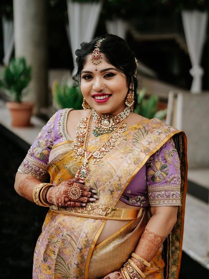The glowing mother-to-be at her baby shower. Her unique yellow and lavender Kanchipuram silk saree was paired with a custom-embroidered lavender blouse.