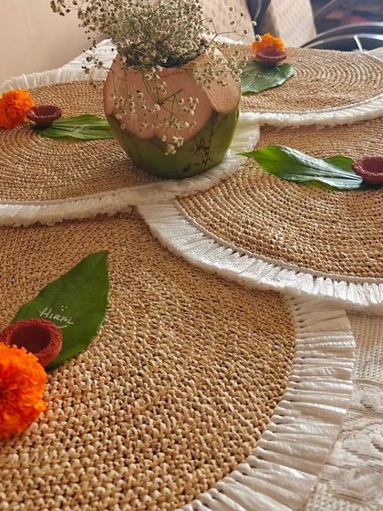 Elegant woven mats and personalized name cards on leaves for a Diwali supper club. These small touches help create a warm and memorable festive atmosphere.