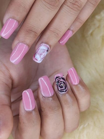 A beautiful set of pink nails with two accent nails featuring hand-painted marble and metallic rose designs.
