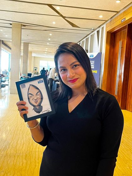 This is a duplicate of ID 70. An attendee from the Tata Mutual Fund event holding her framed digital caricature.