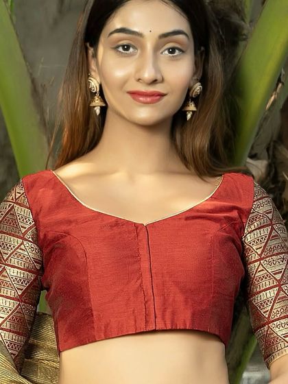 A front view of the maroon blouse with gold brocade sleeves. The simple V-neck and front-opening design provide a flattering and comfortable fit.