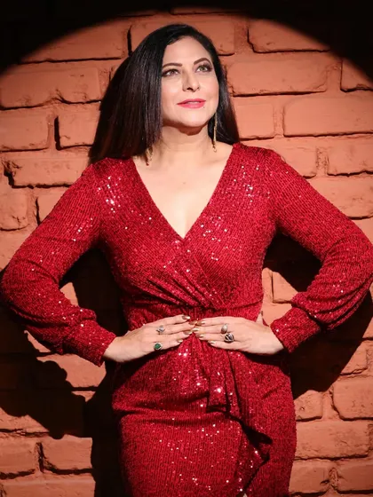 A confident, hands-on-hips pose in the red dress. This classic power pose works well to showcase the fit and style of the garment.