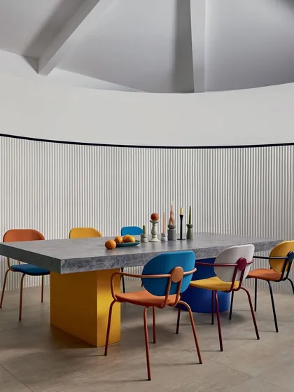 The Pilastre wallcovering from Élitis masterfully uses 3D techniques to create a seamless, repeat-free design echoing classical fluting. It provides a stunning, architectural backdrop for this colorful dining room.