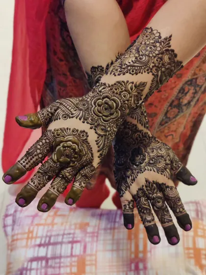 A beautiful rose-themed design with intricate details. The patterns flow beautifully from the fingers up to the forearm.