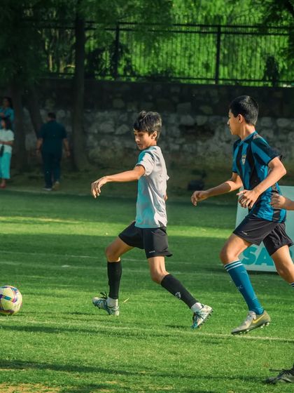 A player dribbles down the line, with a teammate running in support.