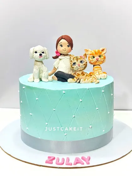 An adorable cake for a girl who loves her pets. The design features a custom edible figurine of her with her dog and two cats.