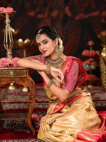 This bride's look is all about traditional elegance. The makeup is classic, with defined eyes and a bold lip, perfectly complementing her antique jewelry.