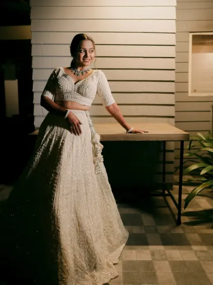 The bride smiles, looking radiant in her all-white ensemble.