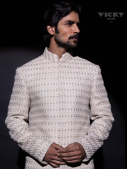 A spotlight on our signature embroidered sherwani. This image captures the texture and presence of a piece designed to be a canvas for your unique style.