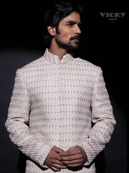 A spotlight on our signature embroidered sherwani. This image captures the texture and presence of a piece designed to be a canvas for your unique style.