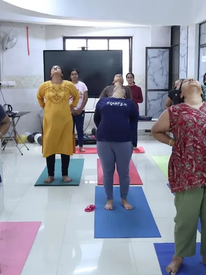 Participants in our free yoga camp practice a gentle neck and shoulder stretch. These warm-ups are essential for preparing the body for asana practice and releasing everyday tension.