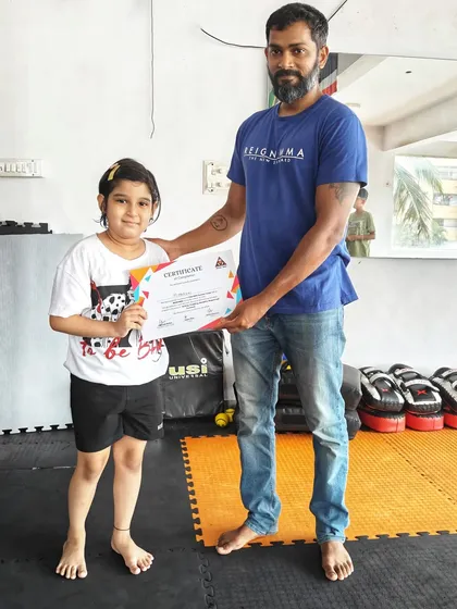We celebrate every achievement, big or small. Here, one of our proud young members receives her certificate for successfully completing our MMA summer camp, a testament to her hard work and dedication.