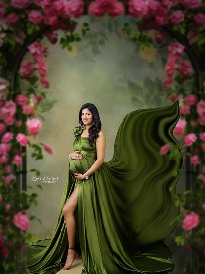 A beautiful maternity portrait set in a floral archway, the green of the gown echoing the colors of nature.