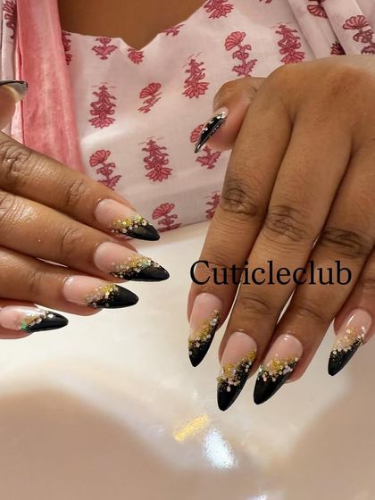 Sharp and chic. These stiletto nails feature a black V-tip that fades into a beautiful gold and black glitter gradient.