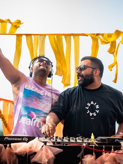 Two DJs collaborate at our Goa Holi event, keeping the energy high. I book multiple artists for my festivals to provide a diverse and continuous musical experience.