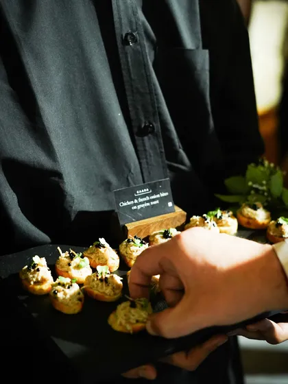 A guest being served our chicken and French onion bites on a gruyere toast. Our pass-around service is designed to be interactive and elegant, ensuring a great guest experience.