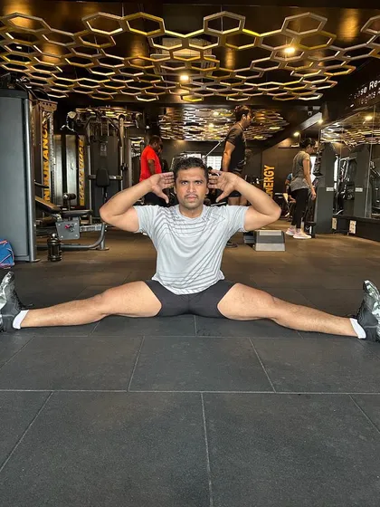 Flexibility is just as important as strength. This client is demonstrating an impressive split, a result of consistent stretching and mobility work.