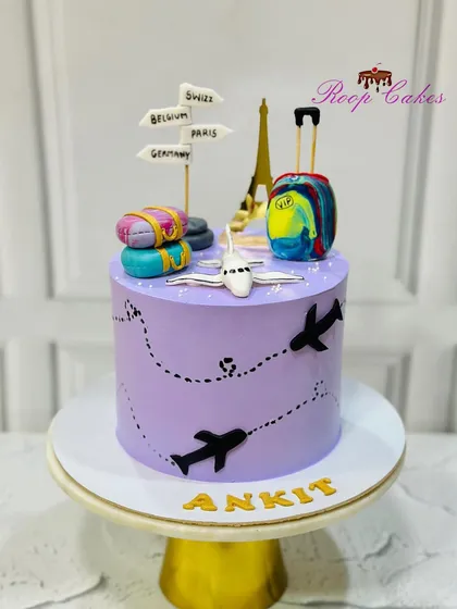 A semi-fondant travel theme cake for Ankit. This purple cake is decorated with airplane silhouettes and topped with a fondant plane, luggage, and signs pointing to dream destinations.
