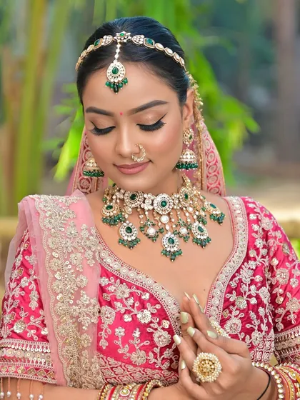 A detailed close-up of the emerald green beaded Kundan necklace, jhumkas, and matha patti. This view shows the quality and craftsmanship you can expect from my rental collection.