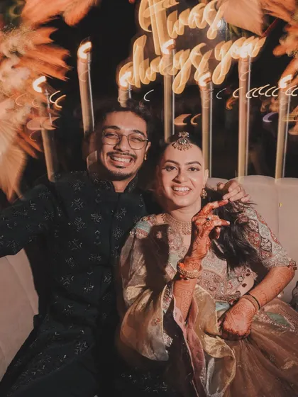 A candid moment of laughter under a neon sign that reads "It was always you." These are the details that add a personal touch to your wedding story.